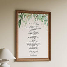 Load image into Gallery viewer, Framed poem on a wall above a wooden shelf with books and a lamp.