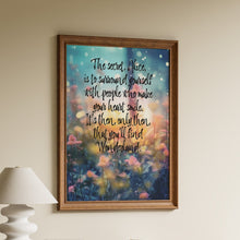 Load image into Gallery viewer, Framed Wonderland-inspired quote print "the secret Alice is to surround yourself with people who make your heart smile" over a floral meadow