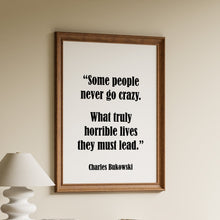 Load image into Gallery viewer, Framed Charles Bukowski quote print reading "some people never go crazy, what truly horrible lives they must lead" above a wooden sideboard