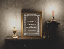 Load image into Gallery viewer, May include: A gold framed picture with a black and white quote that reads 'Scream if you need anything. Morticia Addams.' The picture is on a dark wood shelf with a gold oil lamp and a candle holder with a lit candle.