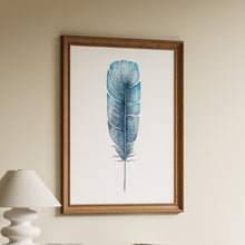 Load image into Gallery viewer, Single watercolour feather painted in teal, sky blue and indigo with fine speckles on a white background in a wooden frame
