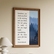 Load image into Gallery viewer, Framed Charles Bukowski quote print about climbing out of bed, paired with a misty blue forest illustration
