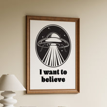 Load image into Gallery viewer, I want to believe in bold black lettering beneath a retro flying saucer beaming light in a starry oval, X-Files inspired print
