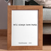 Load image into Gallery viewer, May include: A framed print with a white background and black text. The text reads 'We'll always have Paris.' and 'Casablanca - 1942.' The frame is made of light brown wood.
