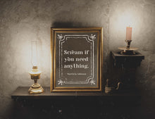 Load image into Gallery viewer, May include: A gold framed picture with a black and white quote that reads 'Scream if you need anything. Morticia Addams.' The picture is on a dark wood shelf with a gold oil lamp and a candle holder with a lit candle.
