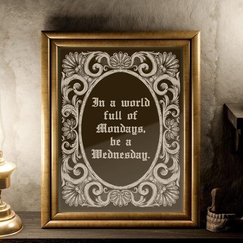 May include: A gold framed mirror with a decorative border. The mirror reflects a candle and a lamp. The mirror has a quote inside: 'In a world full of Mondays, be a Wednesday.'